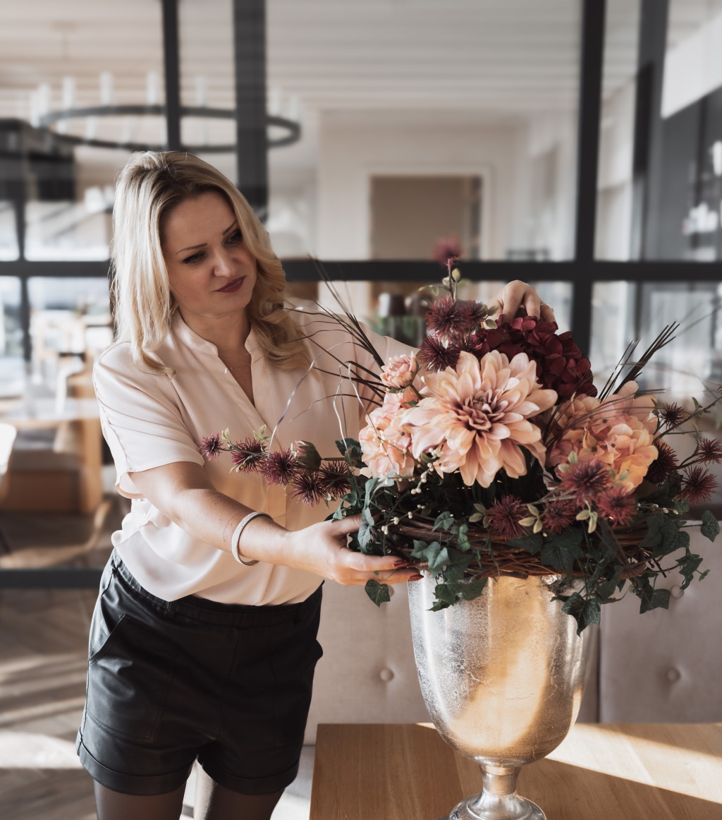 Hochzeitsplanerin rückt Vase zurecht